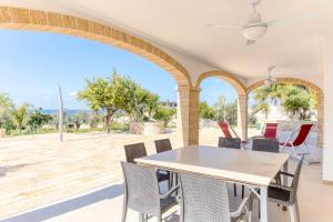 a dining room with a table and chairs on a patio at Villa Bianca Appartament in Ugento
