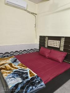 a bedroom with a bed with red pillows at Aastha Krishna Homestay in Mathura