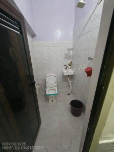 a small bathroom with a toilet and a sink at Aastha Krishna Homestay in Mathura