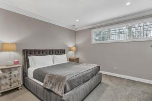 a bedroom with a large bed and a window at Elegant Condo-Steps from Wrigley Field, 32 Nights condo in Chicago