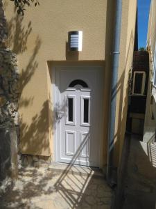 a white door of a building with a window at Holiday Home Ljubičić in Baška