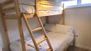 Etagenbett in einem kleinen Zimmer mit einer Leiter in der Unterkunft 5 Penhale in Perranporth