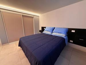 a bedroom with a large blue bed with blue pillows at MiMa Loft in Milano Marittima