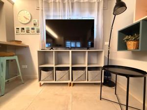 a living room with a tv and a table and a lamp at MiMa Loft in Milano Marittima
