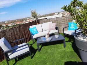 a patio with two chairs and a couch and a table at 360 degrés sur la rochelle chambre d hôte in La Rochelle