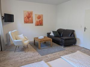 a living room with a couch and a chair and a table at Gästehaus Zeller Altstadt in Zell an der Mosel