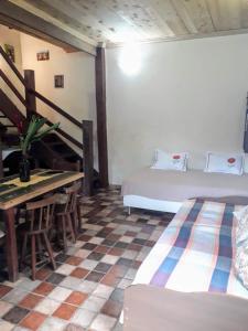 une chambre avec un lit, une table et un bureau dans l'établissement Recanto das Árvores, à Parati