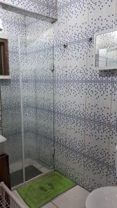La salle de bains est pourvue d'une douche avec un tapis vert. dans l'établissement Recanto das Árvores, à Parati