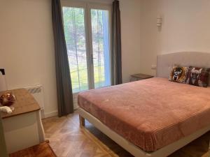 a bedroom with a bed and a large window at Villa Paradis des Oréades in Lauris