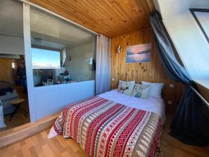 ein Schlafzimmer mit einem Bett mit einem großen Fenster in der Unterkunft Appartement face aux montagnes - Belle étoile in Eyne