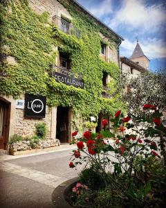 Un edificio con un'edera sul lato. di La vie en rose sur le Larzac a La Vacquerie-et-Saint-Martin-de-Castries