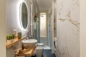 ein weißes Badezimmer mit Waschbecken und Spiegel in der Unterkunft Homeby, Casa Brancaleone in Rom