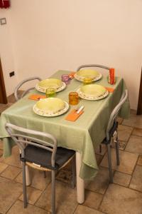 una mesa verde con platos y utensilios. en Alloggio Antony, en Pachino