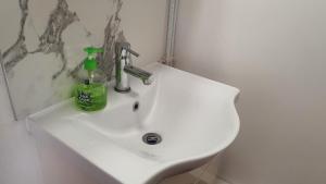 a bathroom sink with a bottle of soap on it at Harbour House - Entire Detached 4BR, Ensuite & Bath, Wi-Fi, Smart TV, Self Catering - Serving Contractors, Tourists, Santa Pod & Silverstone! in Wymington