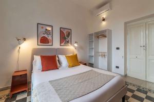 ein Schlafzimmer mit einem großen weißen Bett mit bunten Kissen in der Unterkunft Homeby, Casa Brancaleone in Rom + 32 Fotos