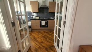 a kitchen with wooden floors and a stove top oven at Harbour House - Entire Detached 4BR, Ensuite & Bath, Wi-Fi, Smart TV, Self Catering - Serving Contractors, Tourists, Santa Pod & Silverstone! in Wymington