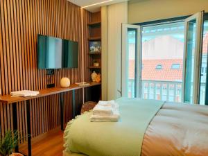 a bedroom with a bed and a tv and a window at Castle Studios in Leiria
