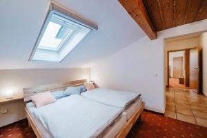 a bedroom with a large bed with a skylight at Haus Josef Hager in Bad Füssing