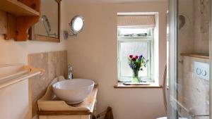 łazienka z wazą kwiatów w oknie w obiekcie Crafty Cottage w mieście Chipping Campden +13 zdjęć