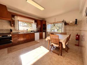 a kitchen with a table and chairs in it at Casa Nabia - Surf & Nature in Ericeira