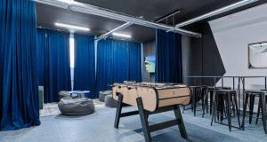 eine Tischtennisplatte in einem Raum mit blauen Vorhängen in der Unterkunft LIVE-INN PRAGUE DELUXE SUITE FOR 1-4 GUESTS, 20 Mins to center, Lift, Gym, Reception, Parking, Roof Terrace, Game & Party in Prag