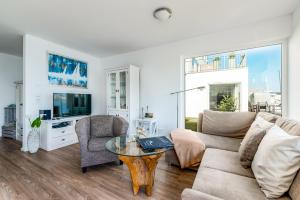 a living room with a couch and a table at Ferienwohnung Brigantine56 in Olpenitz