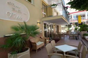 a restaurant with tables and chairs and a balcony at Hotel De La Ville in Rimini