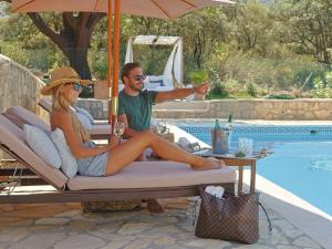 mężczyzna i kobieta siedzący na leżaku obok basenu w obiekcie Traumhaftes Ferienhaus mit privatem Pool und Tennisplatz im Herzen Andalusiens w mieście Alhama de Granada +14 zdjęć