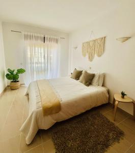 un grande letto in una camera bianca con finestra di Casa Sydney a Lagos