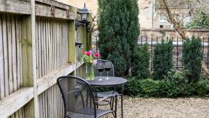 stół z 2 krzesłami i 2 kieliszki wina w obiekcie Crafty Cottage w mieście Chipping Campden
