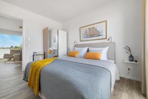 a bedroom with a large bed with two orange pillows at BeachTerraceThree- EG, barrierearm, Meerblick, Terrasse, Kamin, Sauna in Olpenitz