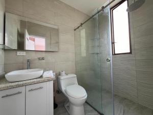 a bathroom with a toilet and a sink and a shower at Luxury Villa with Jacuzzi 4 Bedroom 4 Bath in Baños