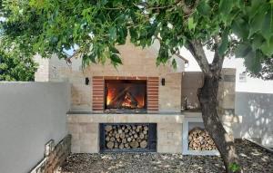 a brick fireplace with a fire burning in it at Villa Solaris in Gradina
