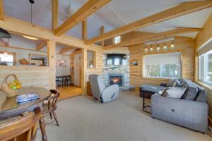 ein Wohnzimmer mit Kamin in einer Blockhütte in der Unterkunft Palmyra Cottage with Deck on Whites Pond! in Coburn