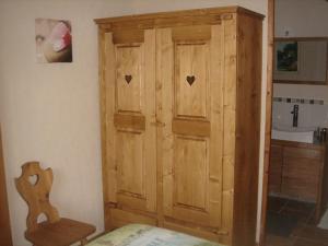 a wooden cabinet in the corner of a bedroom at Gîte Ti-Case in Bussac-Forêt +23 photos