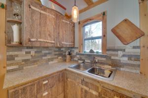 eine Küche mit Spüle und Fenster in der Unterkunft Palmyra Cottage with Deck on Whites Pond! in Coburn + 32 Fotos