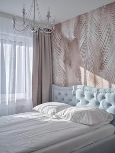 Un dormitorio con una cama con cabecero azul y una ventana. en Prestige Luxury Apartament, en Koszalin
