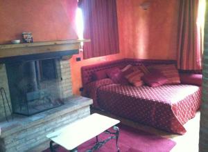 a living room with a bed and a fireplace at Agriturismo La Fenice in Tolè