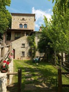 ein großes Steingebäude mit einer Bank davor in der Unterkunft Agriturismo La Fenice in Tolè