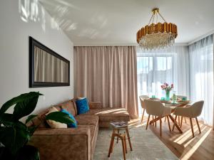 una sala de estar con un sofá y una mesa en Prestige Luxury Apartament, en Koszalin