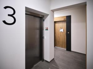 Un pasillo con una puerta con el número tres. en Prestige Luxury Apartament, en Koszalin