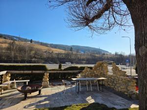 un patio con tavolo e sedie e un muro di pietra di Make Apartment a Spital am Semmering