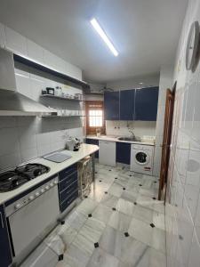 セビリアにあるApartamento Centro Alfonso XIIのキッチン(白い家電製品、青いキャビネット付) +6枚の写真