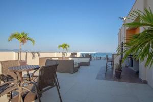 ein Balkon mit Tisch und Stühlen und dem Meer in der Unterkunft Flat Praia de Copacabana - Pé na Areia in Rio de Janeiro