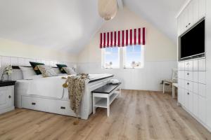 a white bedroom with a bed and a desk at Hafenliebe- Sauna, Steg, Hafenblick, Kamin, Terrasse in Olpenitz