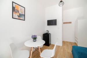 a white living room with a table and chairs at Centrum 5 Łódź 7 Próchnika 21 in Łódź
