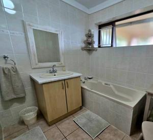 a bathroom with a sink and a tub and a mirror at Remini in Jeffreys Bay +7 photos