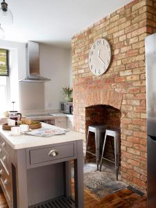 a kitchen with a brick wall with a clock on it at Park Gate in Stamford