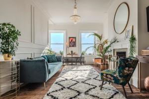 a living room with a blue couch and chairs at The Wellington - style, charm and sea views in Ramsgate