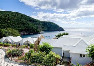 an aerial view of a row of houses next to the water at LES GALETS ROUGES LODGES & SPA in Bouillante